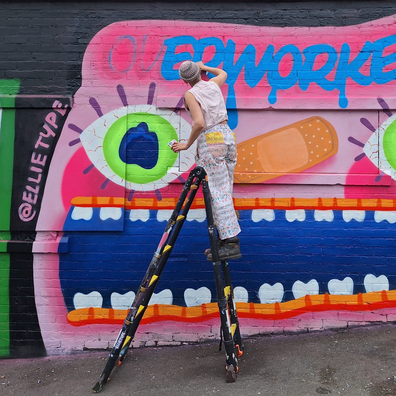 Street Art Künstler der auf einem Graffiti Festival das E in einem Schriftzug malt, Ansicht von hinten, @ellitype ist der Künstler