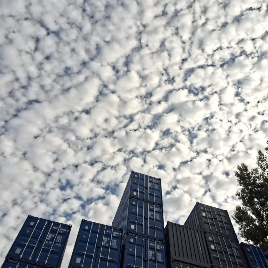 Ein- und auszoomen Hochhäuser unter wolkigem Himmel, Symbol für Struktur und Projektsteuerung.